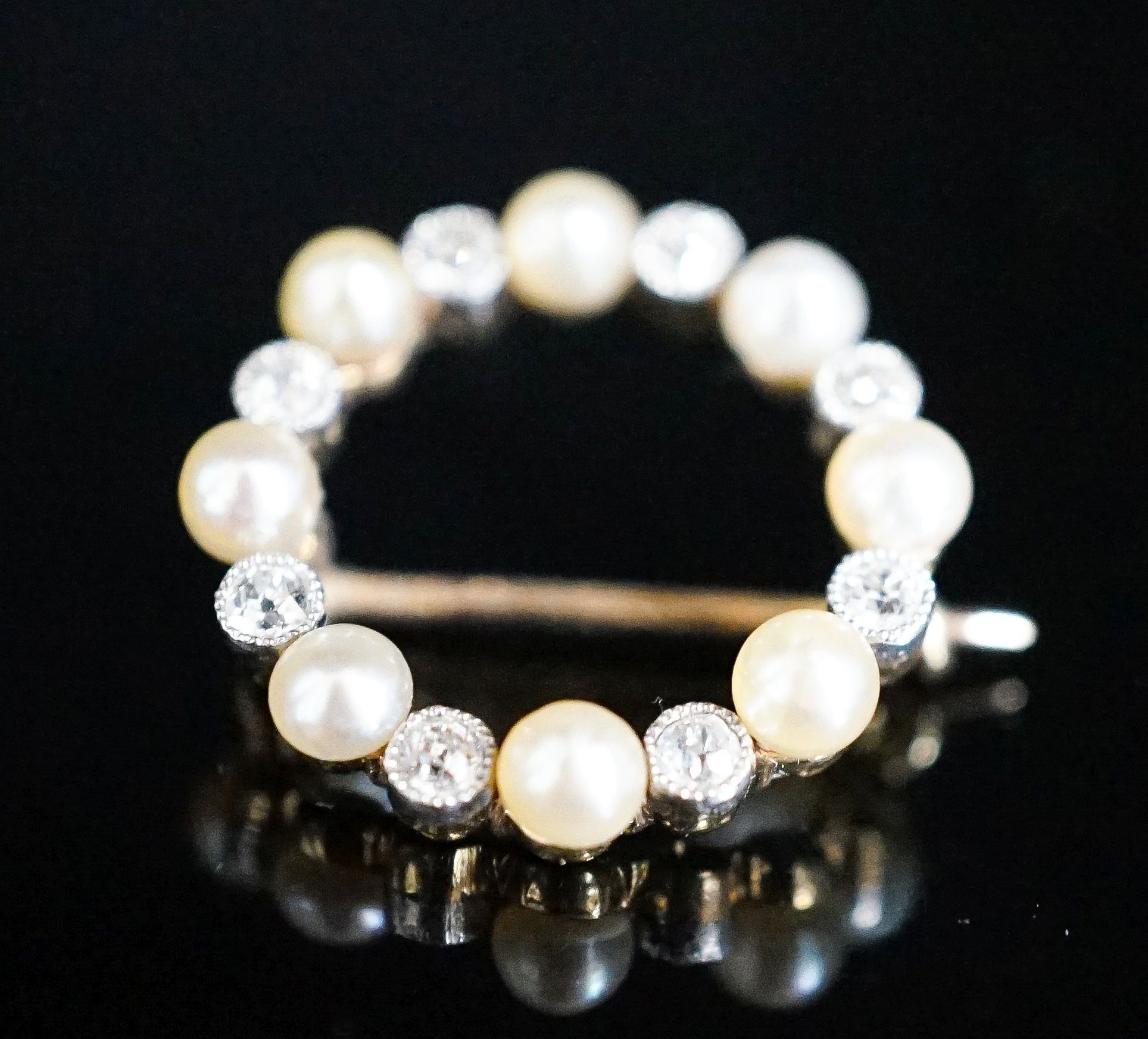 An Edwardian yellow metal, diamond and seed pearl set open work circular brooch, 20mm, gross 2.9 grams.